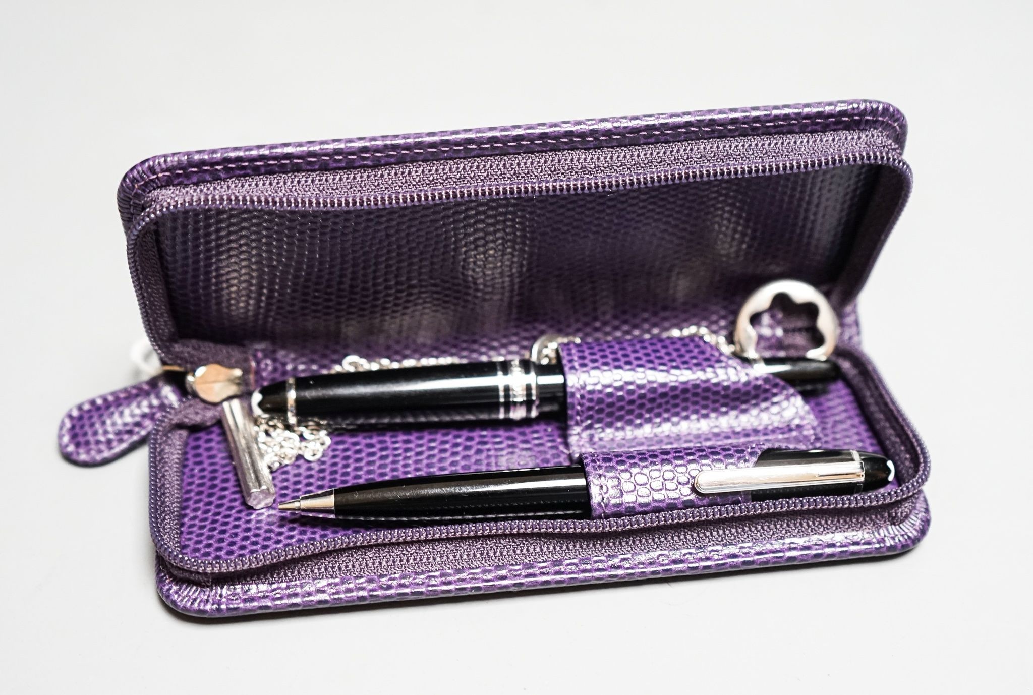 A Montblanc Meisterstuck small fountain, 11.2cm and ballpoint pen, and a chain in a purple case.